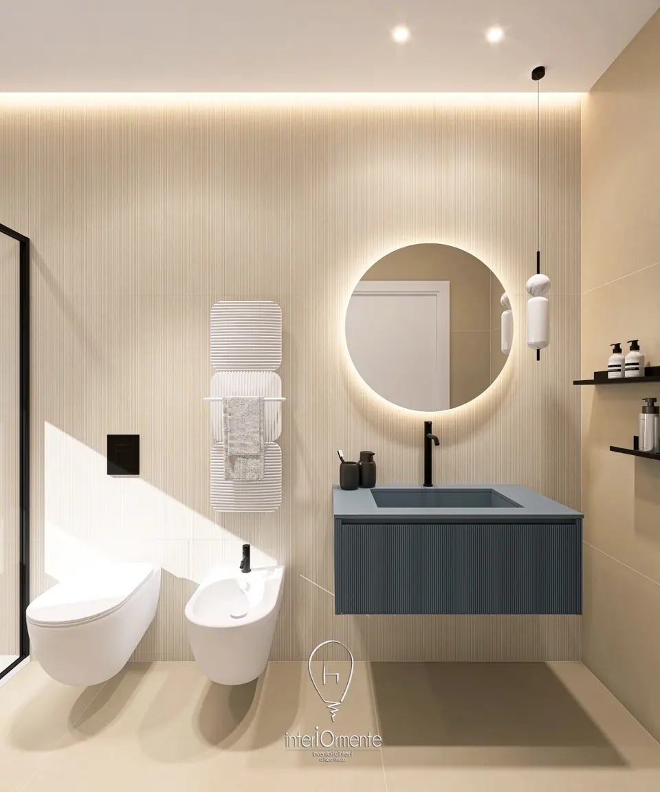 Bagno beige con lavabo blu su mobile cannettato, specchio tondo retroilluminato, scaldasalviette bianco e sanitari sospesi