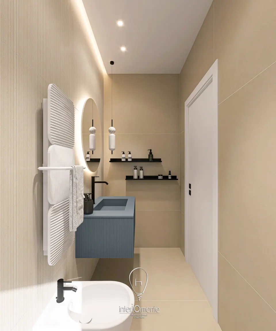 Bagno stretto beige con mobile sospeso blu, specchio tondo retroilluminato, mensole nere e scaldasalviette bianco
