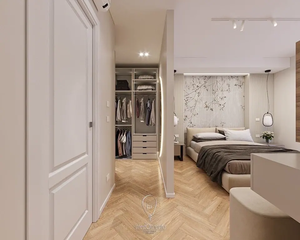 Cabina armadio con cassettiera dietro un divisorio accanto al letto, parquet a spina di pesce