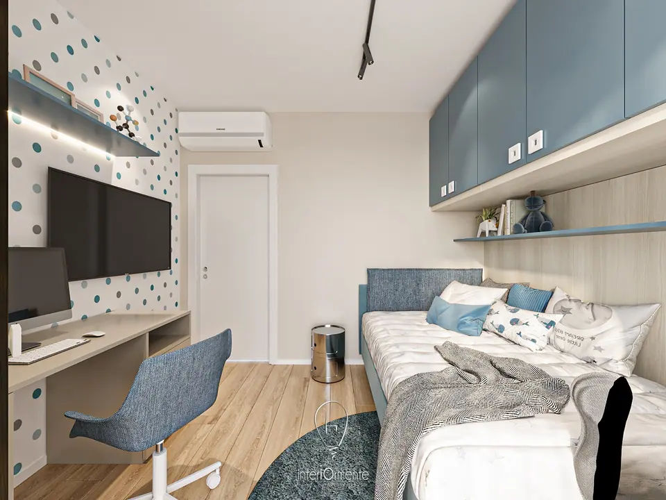 Cameretta con parete a pois, scrivania e televisore, letto imbottito blu e pensili azzurri